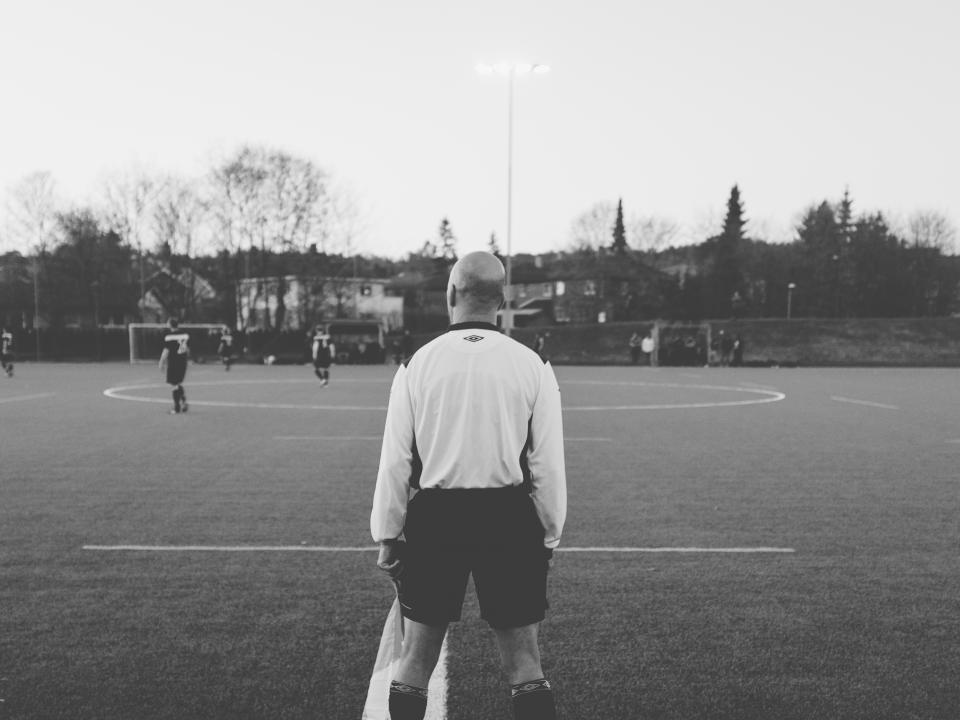 A match official watching play from the touchline
